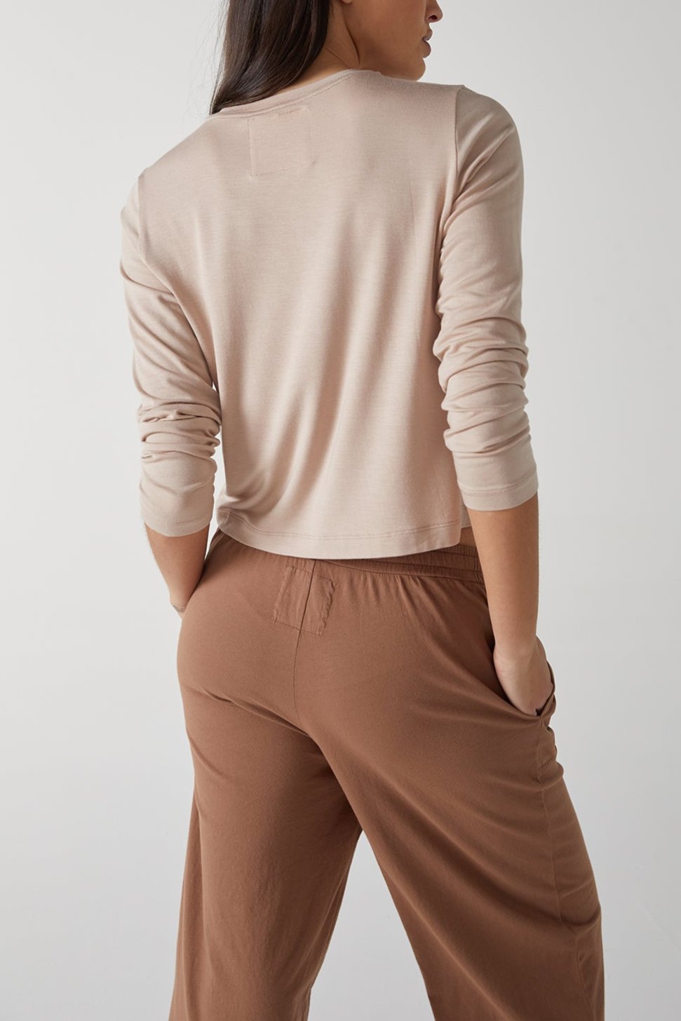   The back view of a woman wearing Velvet by Jenny Graham tan wide leg pants. 