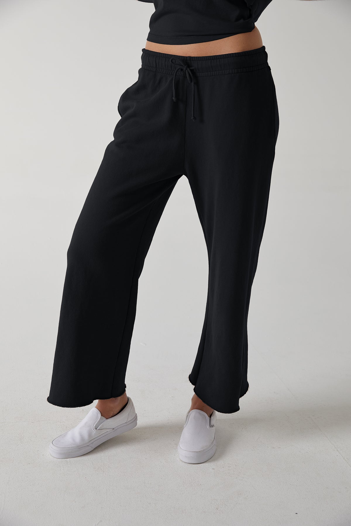   a woman wearing black Velvet by Jenny Graham Montecito sweatpants and a white t - shirt. 