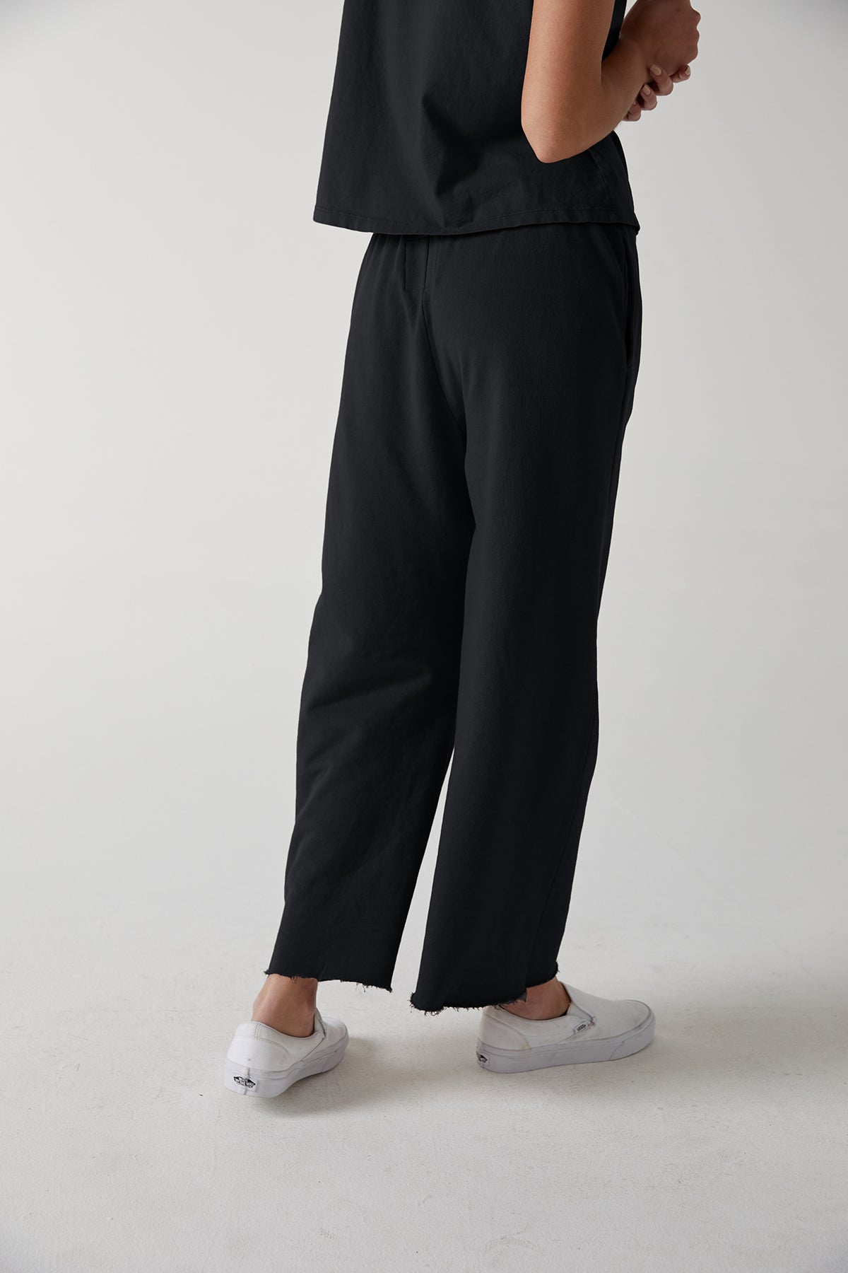   a woman wearing black Montecito sweatpants by Velvet by Jenny Graham and white sneakers. 