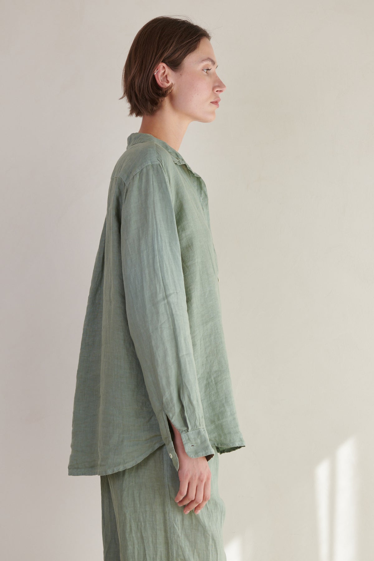   a woman wearing a Green Linen MULHOLLAND SHIRT by Velvet by Jenny Graham and pants. 